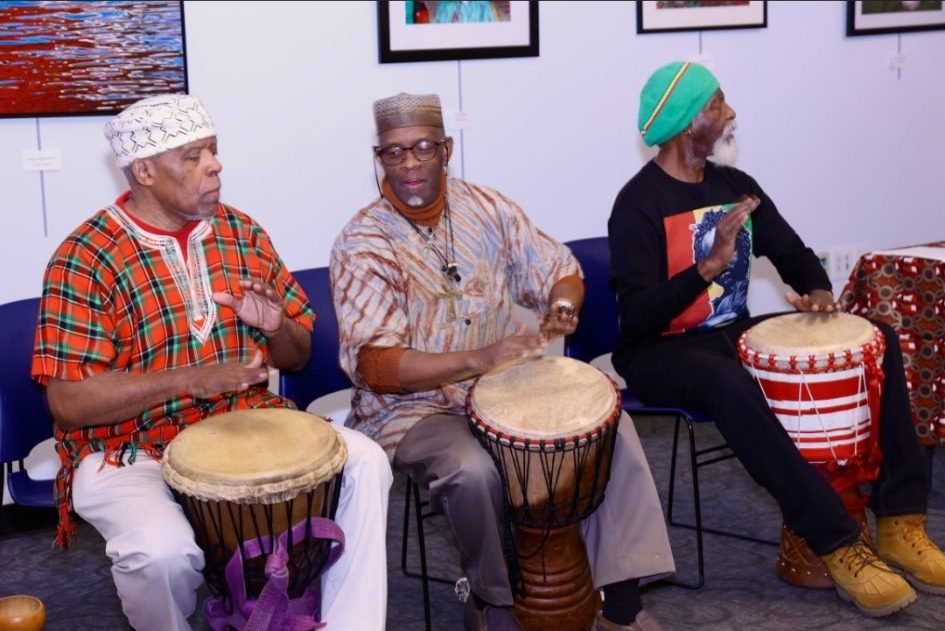 Three drummers playing djembes at the Kwanzaa celebration